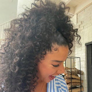 Hannah Bronfman with her curly hair pulled up into a ponywail and laid edges